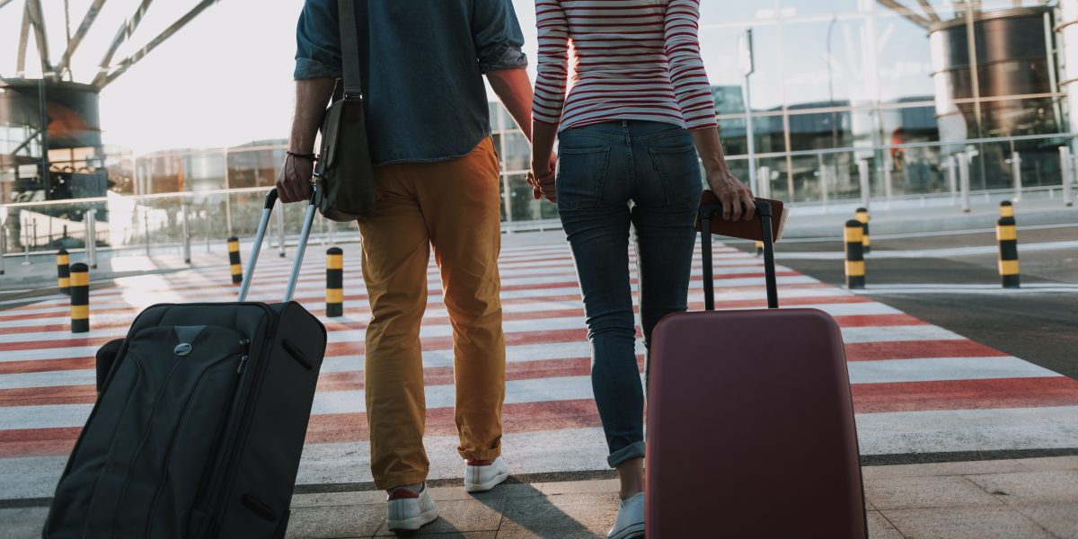 Image commercially licensed from: https://unsplash.com/photos/full-length-back-view-portrait-of-young-man-and-his-charming-girlfriend-walking-and-carrying-their-trolley-bags-ELzj6lPs1h4